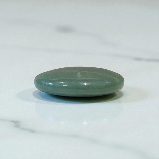 Aventurine pebble on white marble top